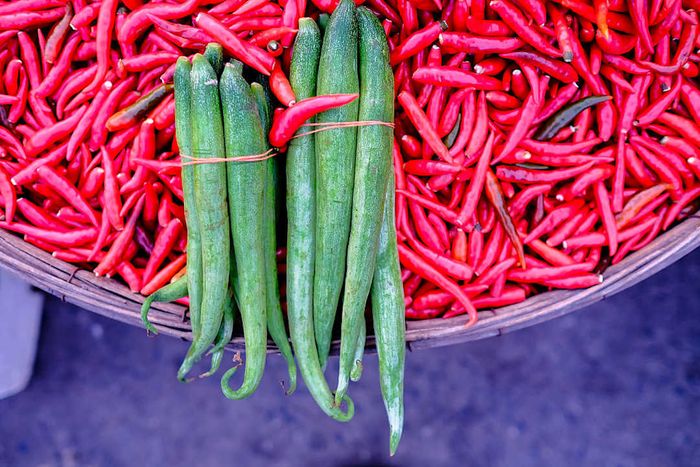 Chili peppers and okra on display at a morning market