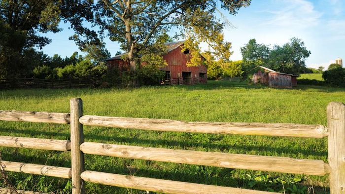 A traditional red barn and wooden fence
