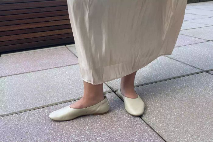 A model showcases Everlane The Italian Leather Day Glove Flats