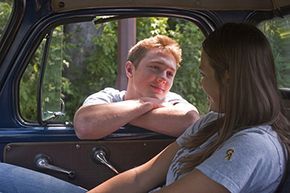 A boy gazing at a girl in a car