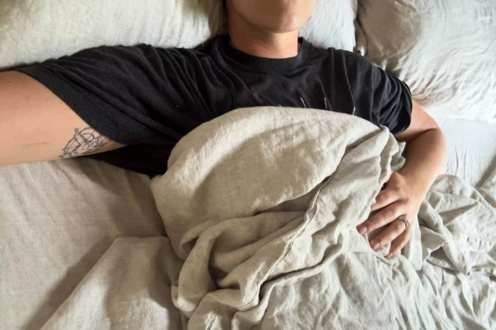A person using the Pottery Barn Belgian Flax Linen Sheet Set