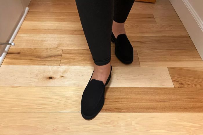 A model wearing Rothy's The Lug Loafers on a wooden floor