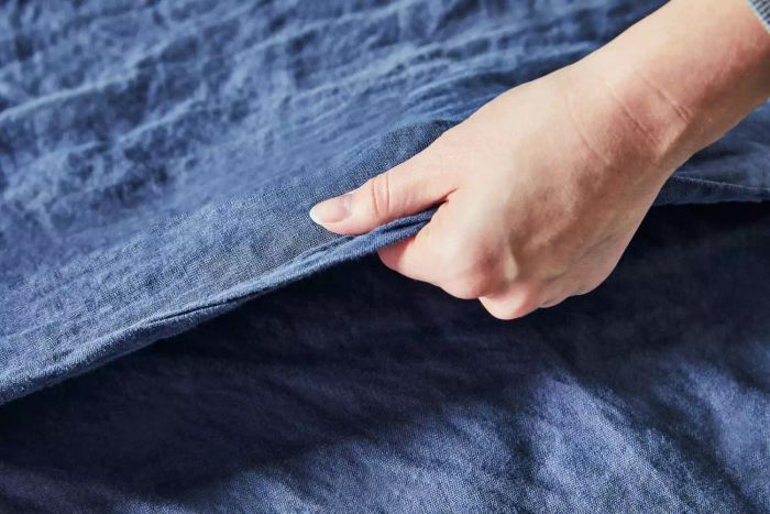 A person feeling the texture of the Citizenry Stonewashed Linen Sheet
