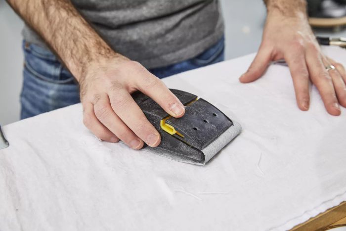 A person using a sanding tool on the Brooklinen Linen Core Sheet Set