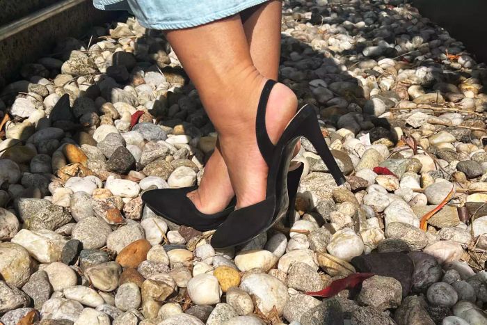 A model standing on rocky terrain wearing the Inez Diana Heels