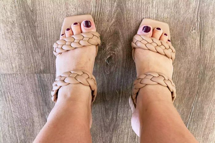 A model wearing the Dolce Vita Paisley Braided Sandal on a wooden floor