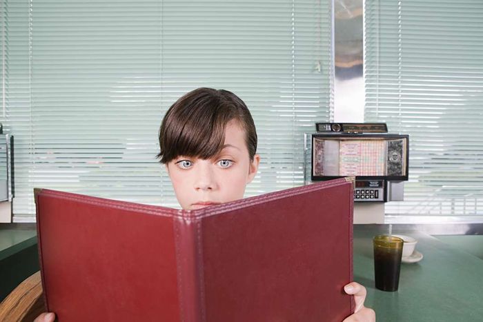 A young girl examining a diner menu