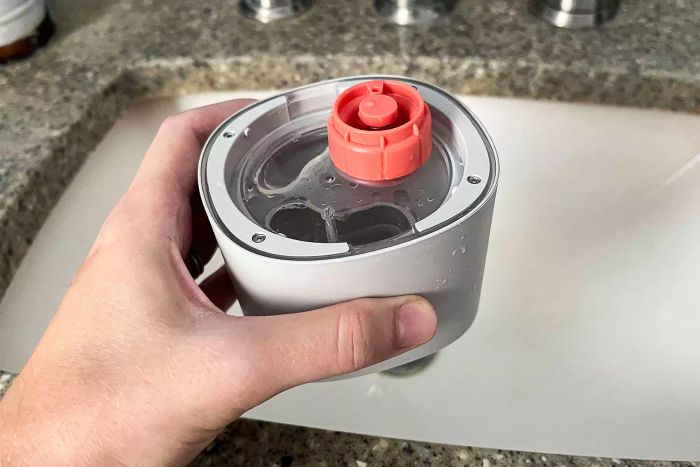 A person is holding the water canister of the Canopy Portable Humidifier
