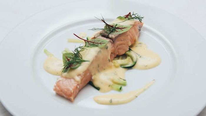 First-class passengers indulged in a delicious serving of poached salmon, complemented by a delicate mousseline sauce.