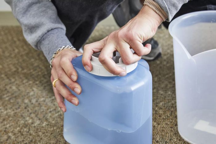 A person is twisting the lid of the water tank for the Honeywell Cool Moisture Humidifier
