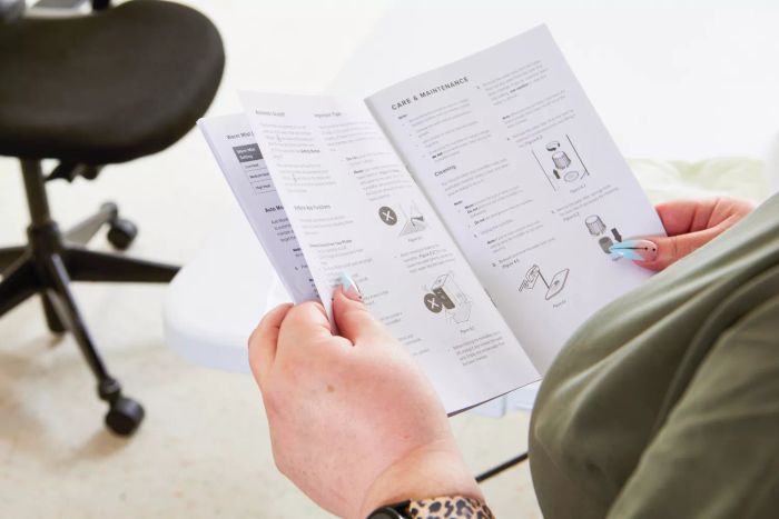 A person is holding the instruction manual for the Levoit OasisMist 450S Smart Humidifier