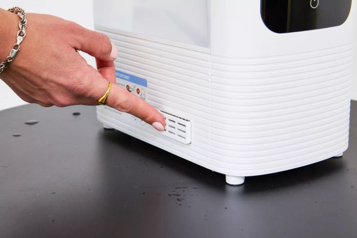 A finger pointing at the side of the Levoit OasisMist 450S Smart Humidifier