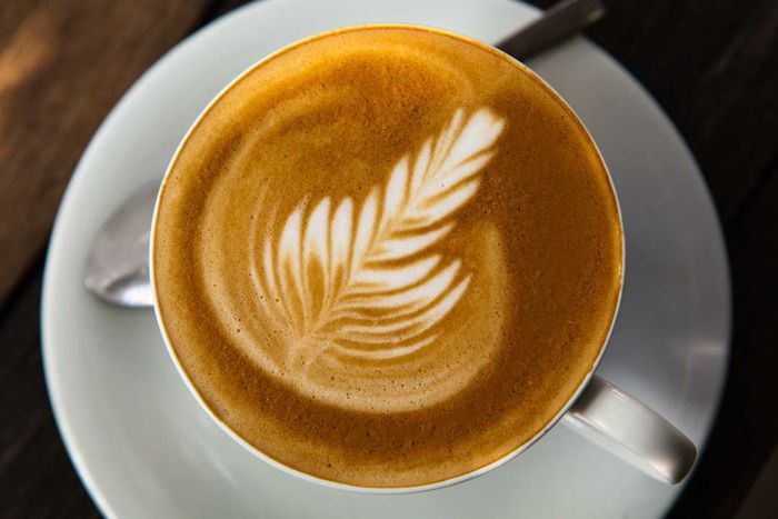 A cup featuring latte art, also known as coffee art.