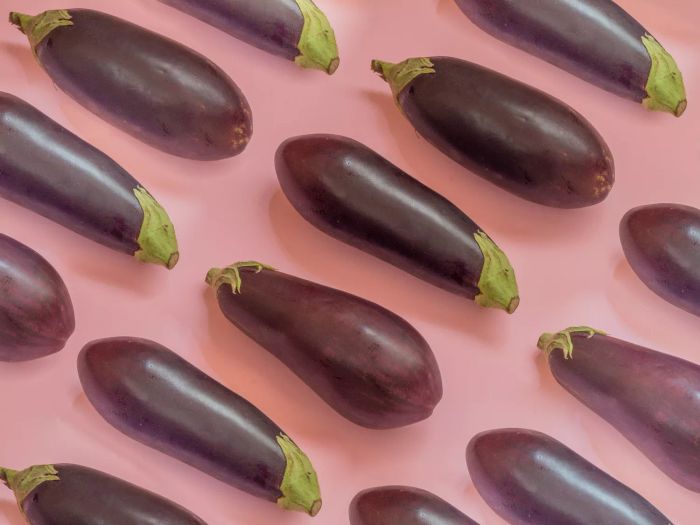 Eggplants displayed on a pink backdrop