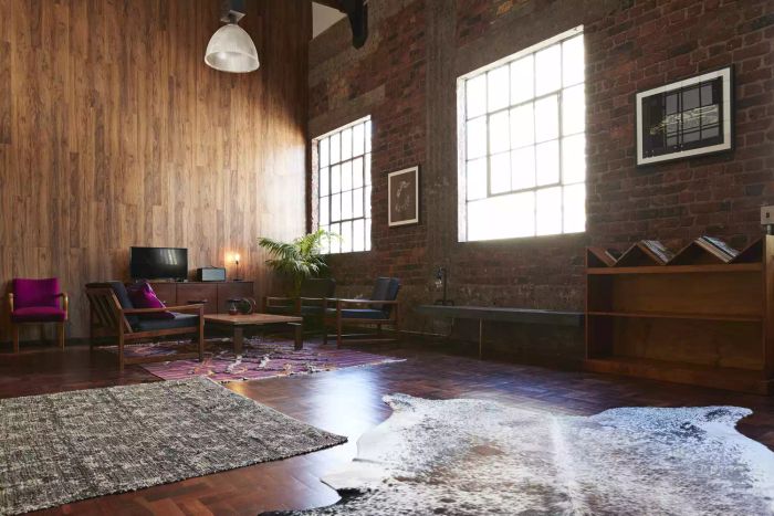 Industrial loft featuring a wood panel wall and paned windows