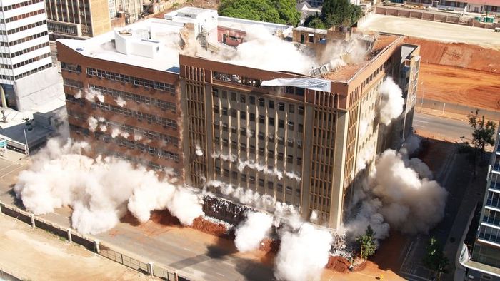 A structure collapsing to the ground as a result of controlled implosion demolition