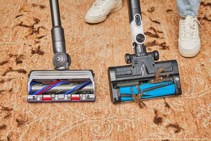 A close-up image of the Dyson V15 Detect Cordless Vacuum Cleaner picking up a mess alongside another vacuum cleaner