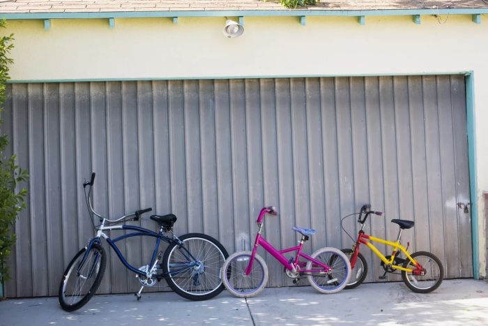 Bicycles parked in front of a shut garage door