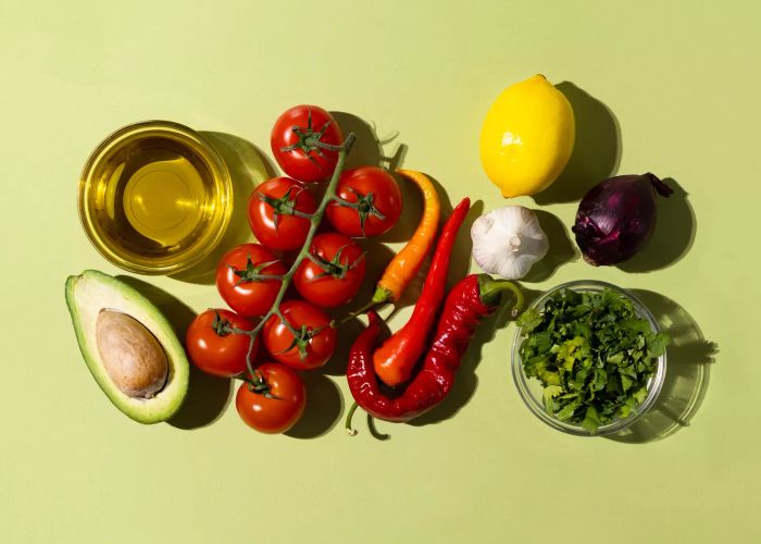 To make Spicy Guacamole, you’ll need these ingredients: avocado, red onion, tomato, chili, lime, cilantro, and garlic.
