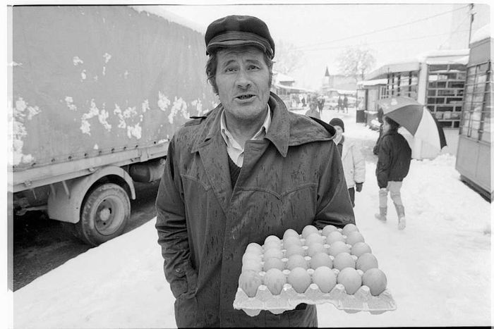 Street Vendor Holding Carton of Eggs