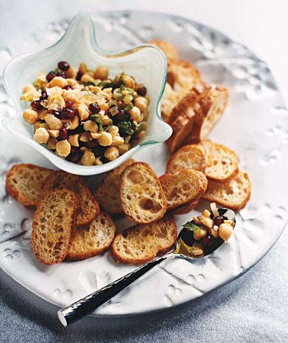 A bowl of chickpea and mint mixture accompanied by toasted crostini, ready to be served