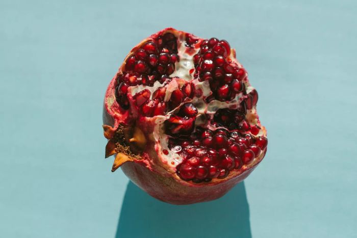 A ripe, freshly halved pomegranate basking in natural sunlight