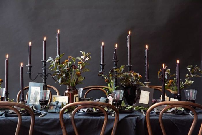 A Halloween dinner celebration featuring black candles and floral accents