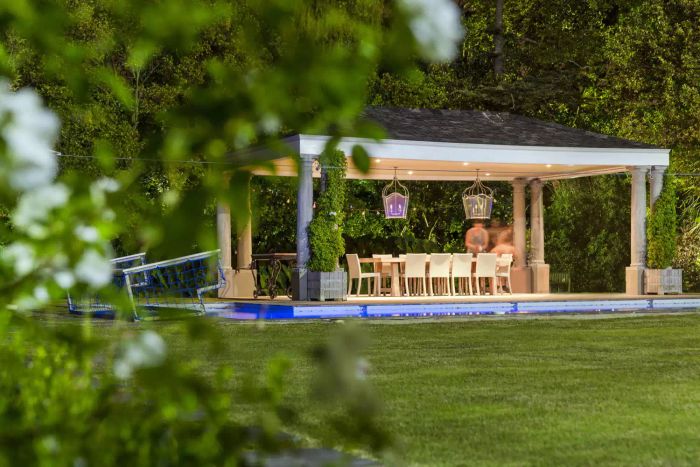 A well-lit gazebo beside a pool