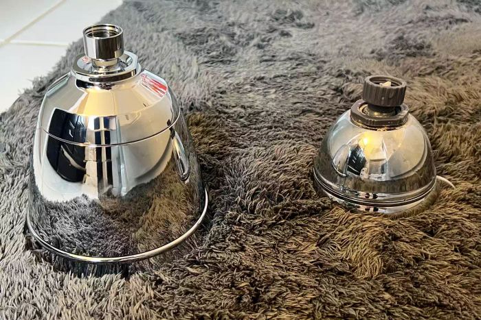 The T3 Source Showerhead placed on a carpet beside another showerhead