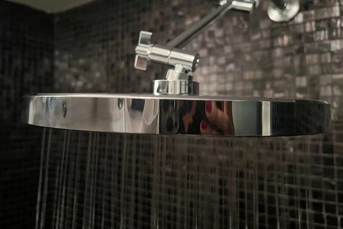 A detailed shot of a level-running KOHLER 76465-G-BN Awaken Rain Shower Head