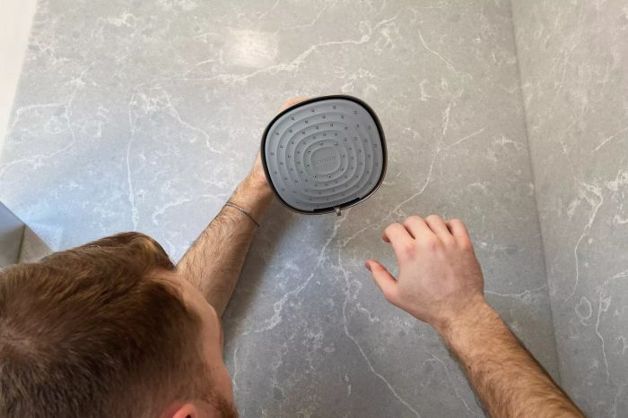 An individual installing the Canopy Filtered Shower Head