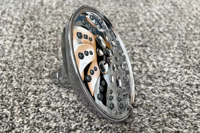 The Delta Faucet 52669-BL 5-Setting H2OKinetic Trad Raincan Shower Head placed on a carpet