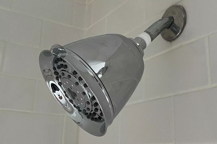 The T3 Source Showerhead installed in a white-tiled shower