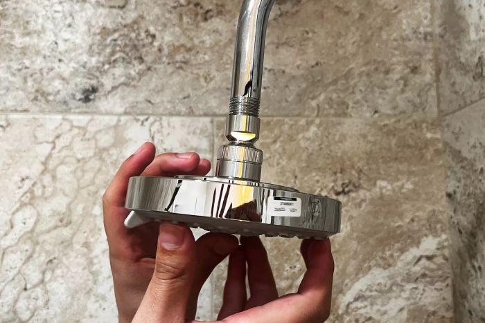 Two hands installing the Hansgrohe Raindance Showerhead