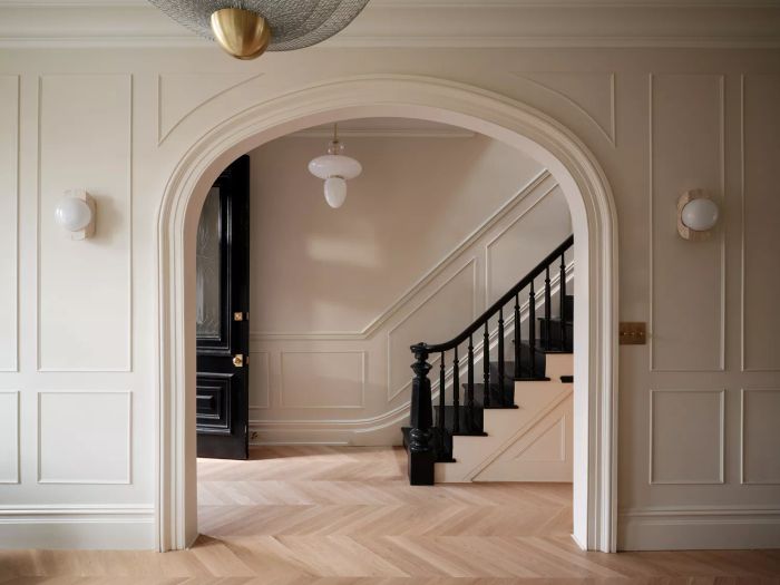 An entryway painted in School House White exudes a welcoming, light-filled atmosphere, setting a peaceful tone as guests enter.