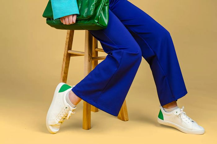 a woman sporting flare pants paired with sneakers