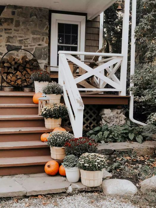 A charmingly decorated front porch with fall-themed decor.
