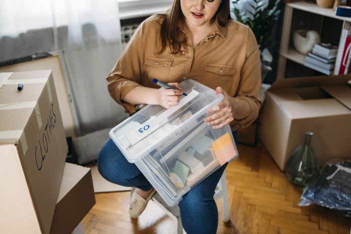 A woman labeling storage boxes