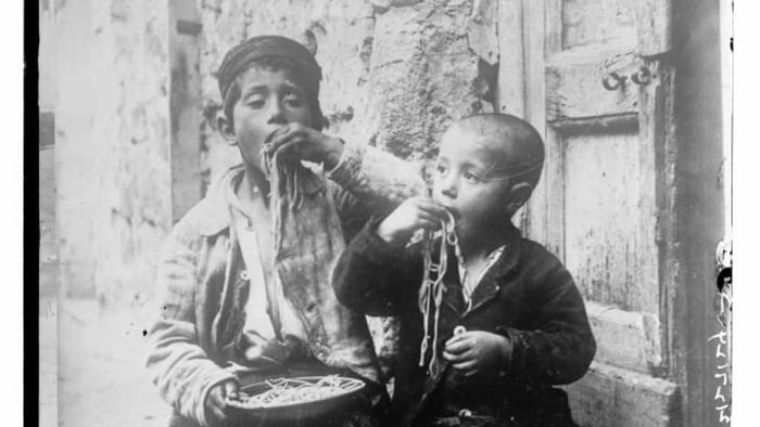 Two boys from Naples enjoying plates of pasta, the date remains uncertain.