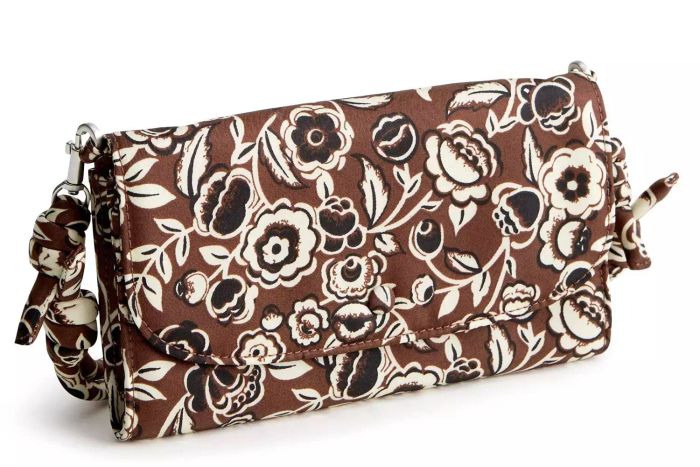 The Vera Bradley Wildwood Wallet Crossbody offers a sleek and practical solution for those who prefer to travel with minimal baggage. This stylish accessory features six credit card slots, a bill compartment, and a secure zippered pocket inside, complemented by two external slip pockets for extra storage. Its versatile design includes a detachable, adjustable strap, allowing it to double as a traditional wallet within a larger handbag.