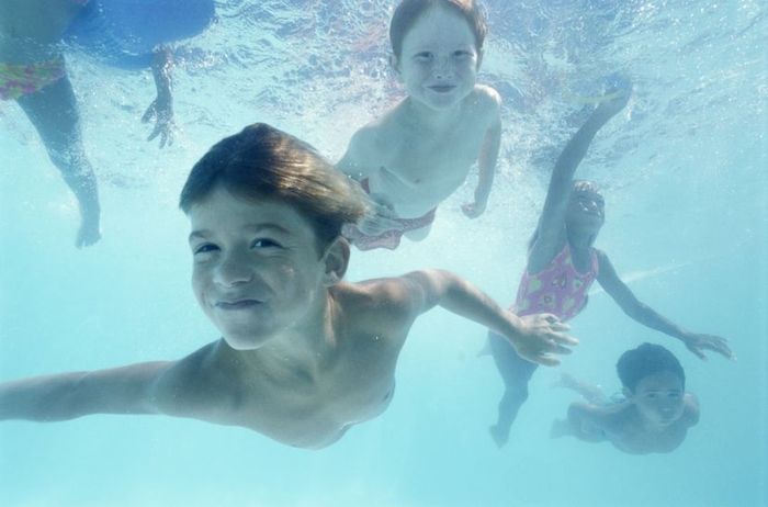 Children dive beneath the surface and swim gracefully.