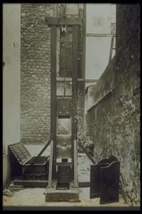 A guillotine stationed in an alleyway in France around 1920.