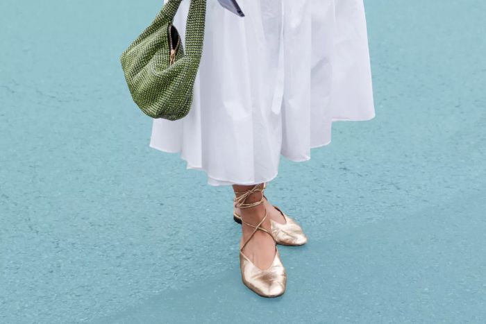 woman wearing ballet flats paired with a white dress