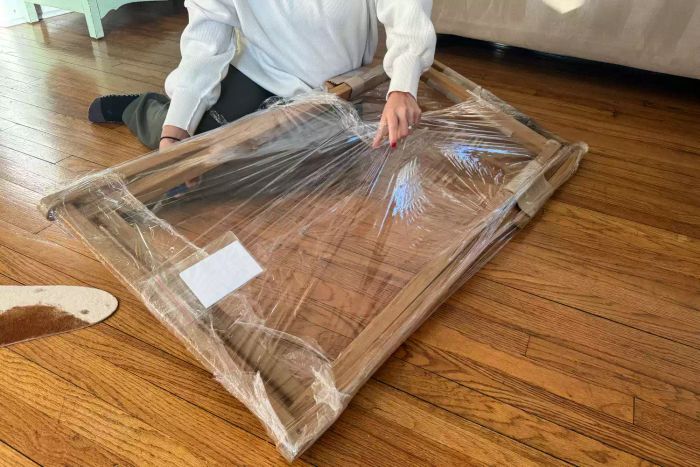 The Serena & Lily Teak Sling Chair in its plastic packaging