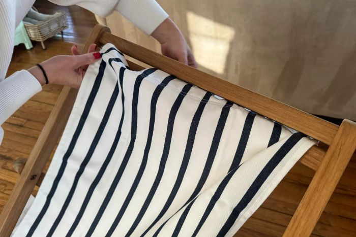 A person assembling the Serena & Lily Teak Sling Chair
