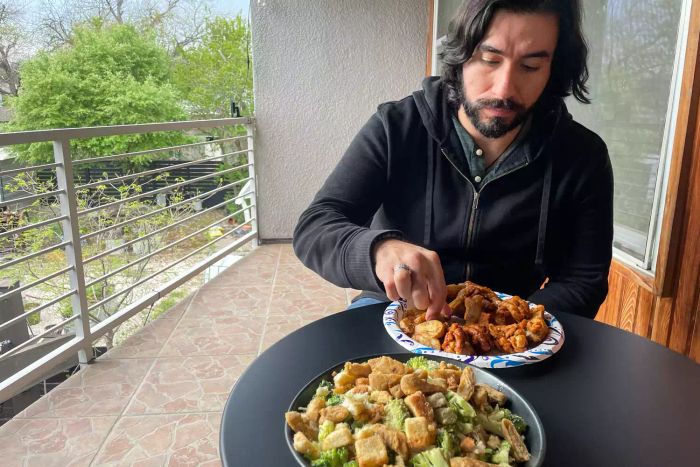 A person enjoying a meal at the Grand Patio 3pc Metal Folding Bistro Set