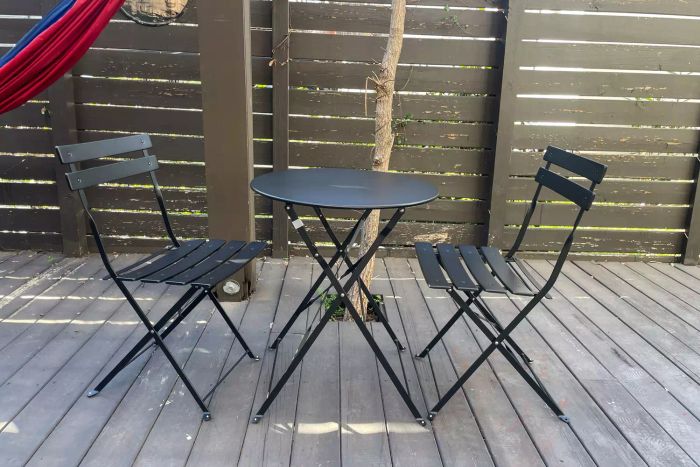 The Grand Patio 3pc Metal Folding Bistro Set placed on a deck
