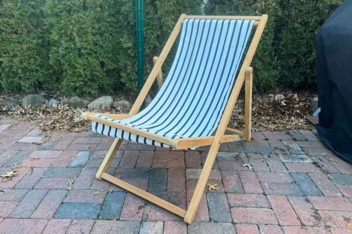 The Serena & Lily Teak Sling Chair placed on a brick patio