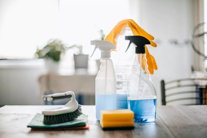 A top-down view of an assortment of cleaning supplies and tools.