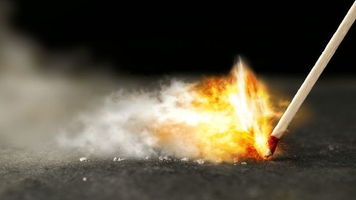 A wooden kitchen match being struck against a surface.